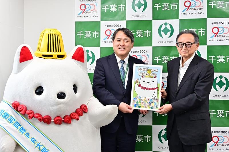 かるたを寄贈した加曽利貝塚博物館友の会の萩原理事長（右）＝２３日、千葉市役所
