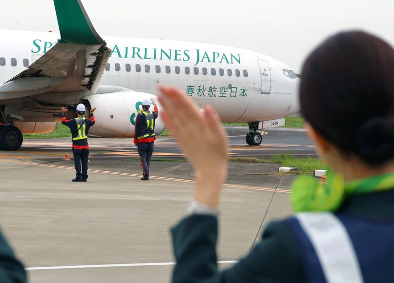 成田空港から函館に向かう旅客機を見送るスプリング・ジャパンのスタッフら＝２３日、成田市