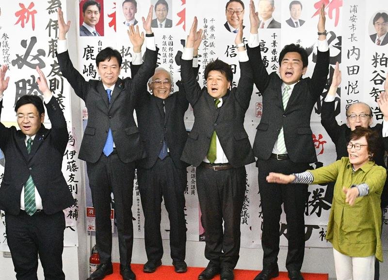 再選を決め、万歳して喜ぶ伊藤氏（左から４人目）＝２６日午後１０時３５分ごろ、香取市
