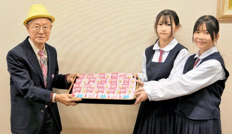小見川中の新入生に防犯ブザーを贈った小山田会長（左）＝香取市
