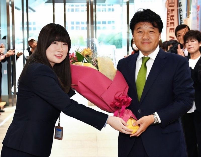 市役所ロビーで市職員から花束を受け取る伊藤市長（右）＝１日、香取市