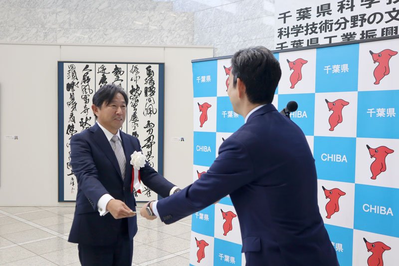 表彰状を受け取る津覇さん＝県庁
