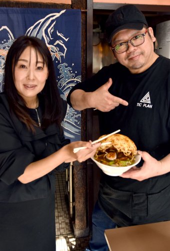 名物メニュー「五目やきそば」を持つ洋一さん（右）と妻のりなさん＝香取市
