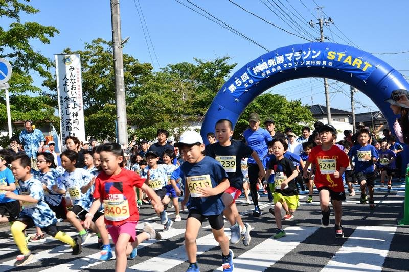 神崎発酵マラソンの参加賞の藍染めＴシャツなどを着て元気よく走る子どもたち＝１７日、神崎町
