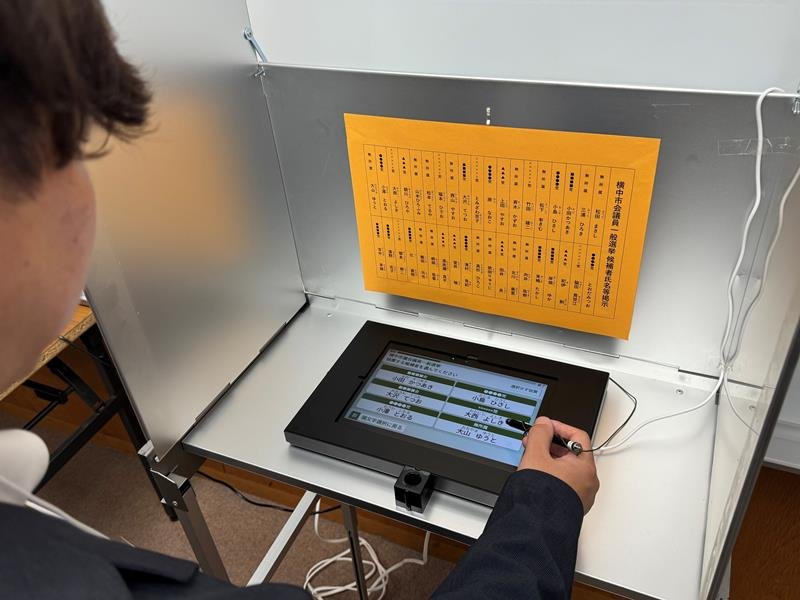 タブレット端末を使った電子投票のイメージ。市長選など候補者が少数の場合は、１画面に表示された全候補者名の中から１人を選択し投票する＝２８日、流山市
