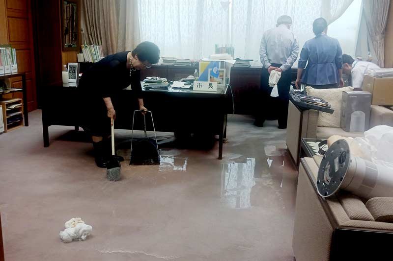 腐食した配管のあった市長室で漏れ出した水を片付ける照川市長ら＝２８日、勝浦市役所