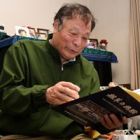 柏陵時代の写真を見る蒲原弘幸。各校の教え子から食事会の誘いなど連絡は今も絶えず、「指導者の冥利（みょうり）に尽きる」＝２月、千葉県内

