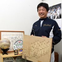 甲子園初出場時の写真を持つ森下倫明。準優勝した２０００年の記念品も大切に保管されている＝浦安市