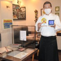 県から贈られた認証制度のステッカーを手にする鈴木シェフ＝２２日、千葉市中央区