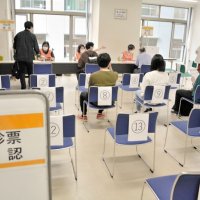 予診票を確認してもらい、接種を待つ学生たち