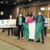 ホテルに到着して手を振るナイジェリア選手団の役員らと出迎えた渡辺市長（右）ら＝７日、木更津市