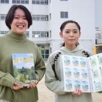 イベントのカードや制作した地域紹介冊子を手に取る千葉商科大生