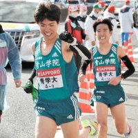 青学大８区佐藤一世（右・八千代松陰高出）が９区中村唯翔（流通経大柏高出）にたすきをつなぐ。大会新記録で総合優勝した＝横浜市戸塚区