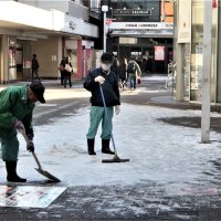 凍結した雪を取り除く作業＝７日午前９時、船橋市のＪＲ船橋駅前