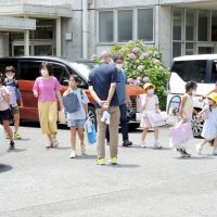終業式を終え、保護者の迎えで帰宅する児童たち。照りつける日差しの下でも、マスク姿も多かった＝２０日午前１１時１０分ごろ、柏市手賀の手賀東小