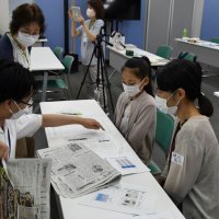 編集局員（左）から新聞記事の執筆方法や紙面作りについて教わる参加者ら＝千葉市中央区