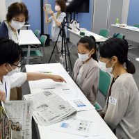 編集局員（左）から新聞記事の執筆方法や紙面作りについて教わる参加者ら＝千葉市中央区