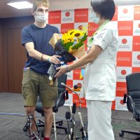 退院を祝い、アントン・コルニシュクさん（左）にヒマワリの花束が贈られた＝２６日、千葉市中央区の千葉大病院