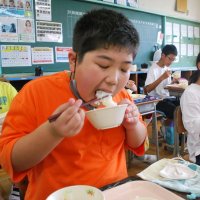 地元産の新米コシヒカリを頬張る児童＝２日、白子町立南白亀小
