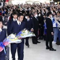 サッカーＷ杯カタール大会を終え、帰国した森保一監督（左下）ら日本代表を出迎える大勢の人たち＝７日、成田空港（共同）