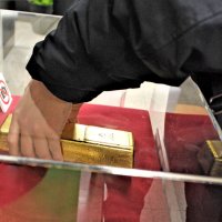 ケースの穴に手を通して金塊の重みを体験するコーナー
