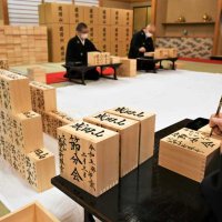 節分会の豆まきで使用する福枡に筆を入れて仕上げていく成田山新勝寺の僧侶＝１１日、成田市