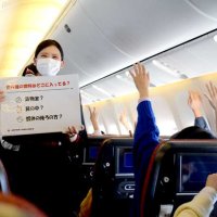 三択式クイズで児童に飛行機に関する知識を教える日本航空の客室乗務員