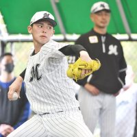 ブルペンで投げ込む千葉ロッテの佐々木朗。奥は吉井監督＝２日、沖縄県石垣市
