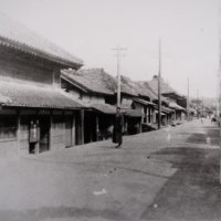 １９１３年の城下町通り。左手前ののれんが下げられた建物が「伊勢幸」。通りと比べて一段低いことが分かる（大多喜町史から）
