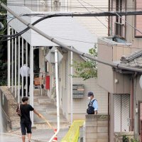 現場のアパート駐車場付近で警戒にあたる警察官＝２９日午後１時１０分ごろ、千葉市中央区