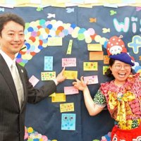 アート作品の一部となる付せんを貼り終え、山武市出身のアーティスト、バルサミコヤスさん（右）と記念撮影する熊谷知事＝１１日、松戸市
