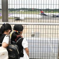 成田空港の展望デッキから滑走路を眺める子どもたち＝２４日、成田市
