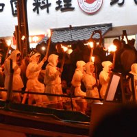 たいまつを持って海へと入る海女さんたち＝１５日夜、南房総市