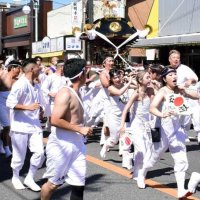 玉前神社門前の商店街を駆け抜ける担ぎ手＝１３日午後１時１５分ごろ、一宮町