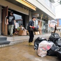茂原市内で浸水被害を受けた店内から濡れた機材などを運び出す男性ら＝９日午前１０時２５分ごろ、同市八千代
