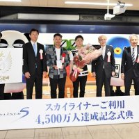 ３代目京成スカイライナーの利用客４５００万人達成を祝う式典に出席した荻原さん（中央左）と北島さん（同右）＝１２日、成田空港駅