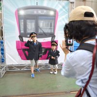 新京成の制服を身にまとい写真撮影する子ども