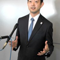 台湾への出発前に報道陣の質問に答える熊谷知事＝１３日午前、成田市の成田空港