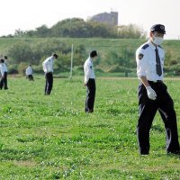 現場近くの江戸川河川敷を捜索する警察官＝９日午後１時５０分ごろ、松戸市古ケ崎