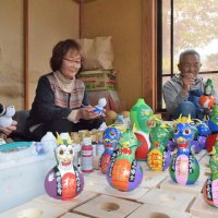 自家栽培のヒョウタンに、来年のえとの「辰（たつ）」を描き込む民芸倶楽部の住民たち＝匝瑳市