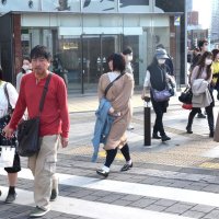 季節外れの暑さの中、半袖姿や上着を手に持ち歩く人たち＝１６日、千葉市中央区