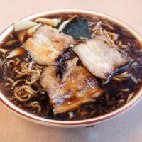 まっ黒な濃厚しょうゆ味のラーメン。厚切りチャーシューや乾麺とよくなじむ
