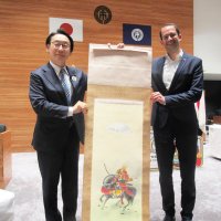 田中市長（左）から記念品を贈られ、笑顔のメルツ市長