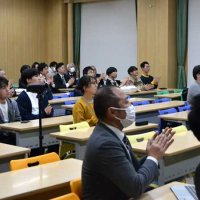 放出成功が分かり拍手するパブリックビューイングの来場者たち＝１１日夜、習志野市の千葉工業大学津田沼キャンパス