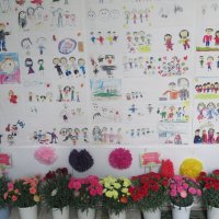 駅改札前に飾られた、近くの小学校などの子どもたちが描いた家族の絵。下はＪＡいちかわ寄贈のカーネーション＝３０日、市川市
