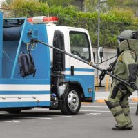 テロ対策訓練で、爆発物が入った想定のリュックサックを専用車両に撤去する県警の専門部隊＝１０日、船橋市浜町
