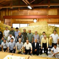 金色煮輝く鯉の前で完成を祝う八日市場区の住民ら＝６月３０日