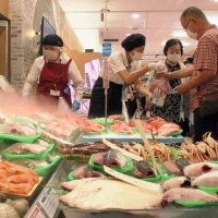 対面鮮魚コーナーで商品を購入する買い物客＝１９日、成田市