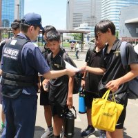 水難事故防止の啓発リーフレットを受け取る学生ら＝１９日、千葉市美浜区のＪＲ海浜幕張駅前
