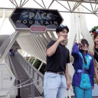 スペース・マウンテンの前で従業員と記念撮影する来園者＝３１日、浦安市の東京ディズニーランド